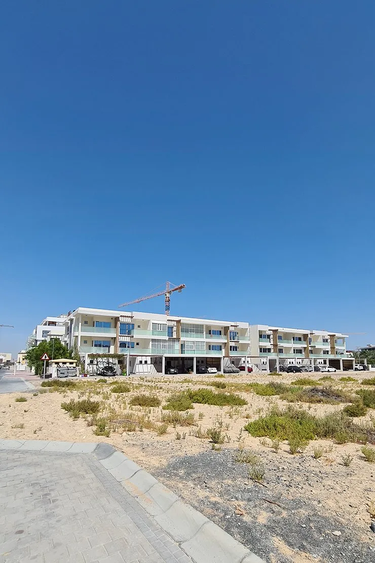 Long facade with carport level and glass balconies