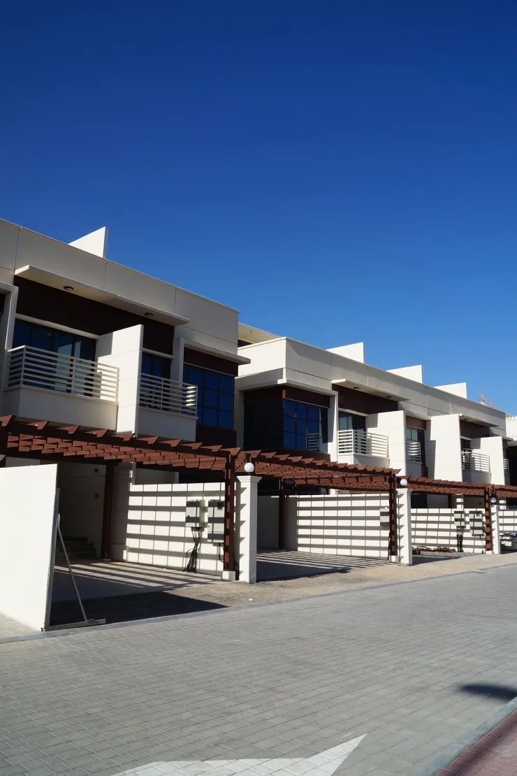 Row of cream townhouses with wooden pergolas