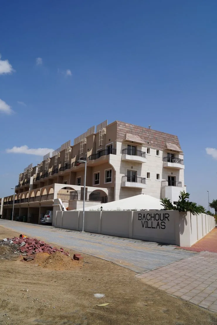 Bachour Villas signage wall with low-rise townhouse block