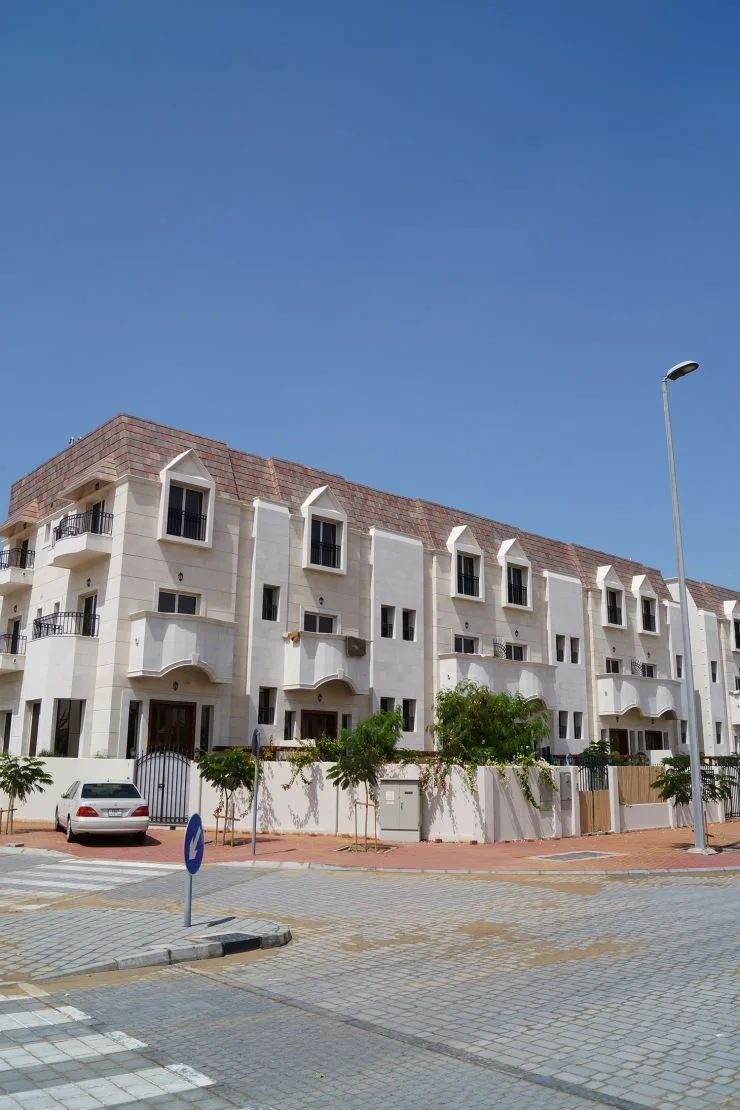 Cream three-storey townhouses with balconies and tiled roof
