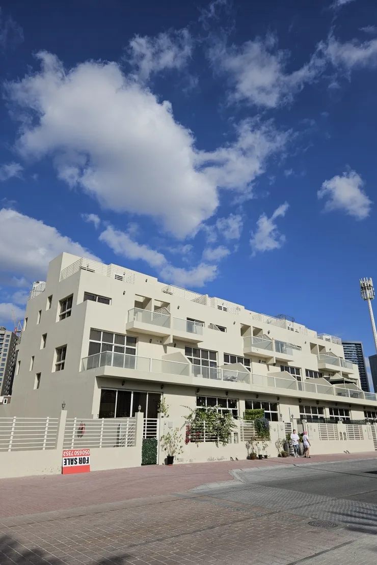 Cream low-rise block with balconies, street view