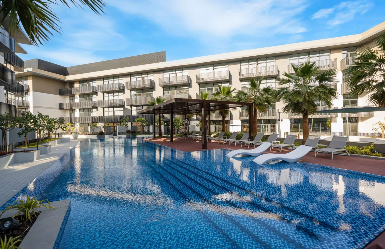 Courtyard pool with loungers and building behind