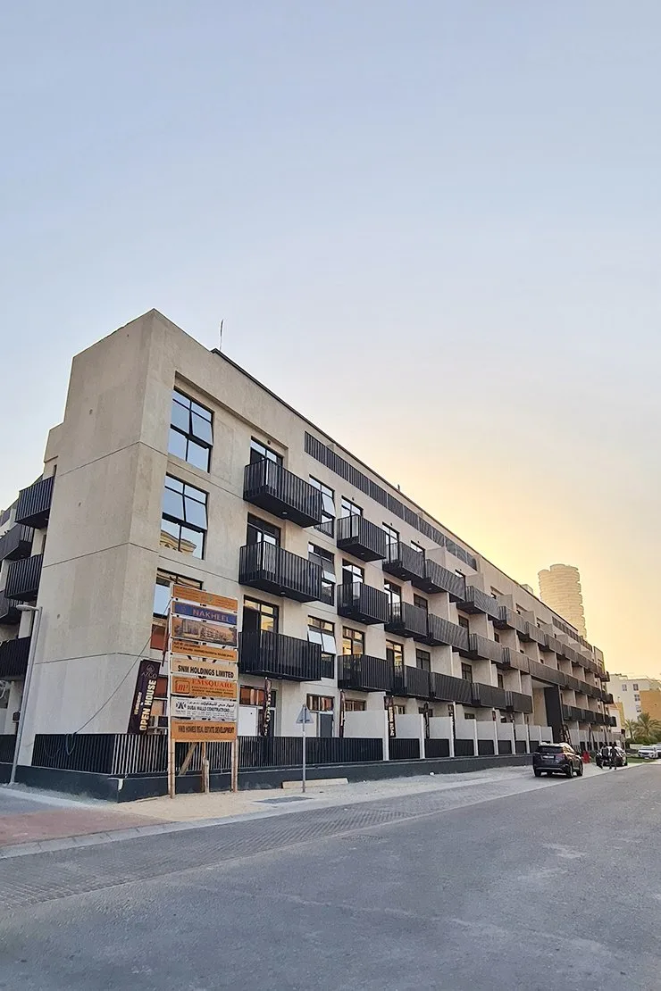 Beige building with black balconies, street view