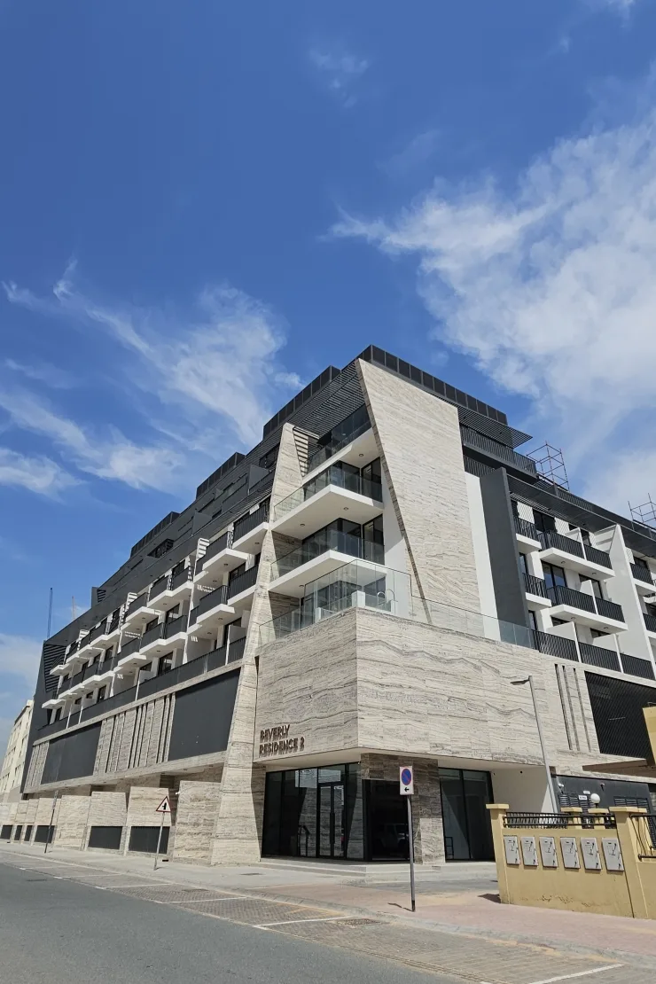 Completed building corner with travertine facade and signage