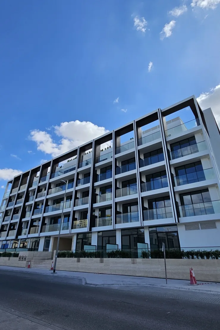 Six-storey facade with black frames and glass balconies