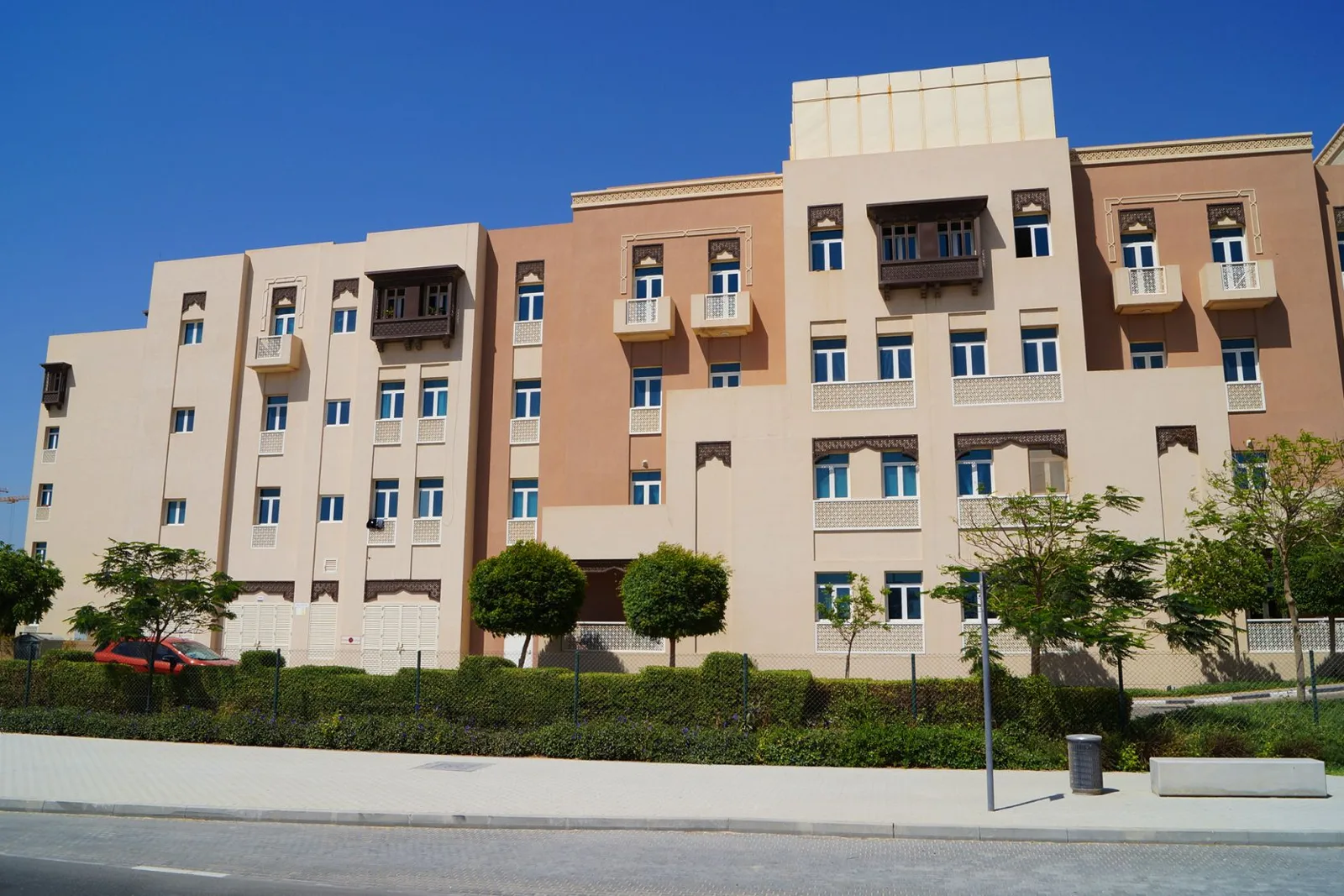 Four-storey beige and peach block with mashrabiya balconies