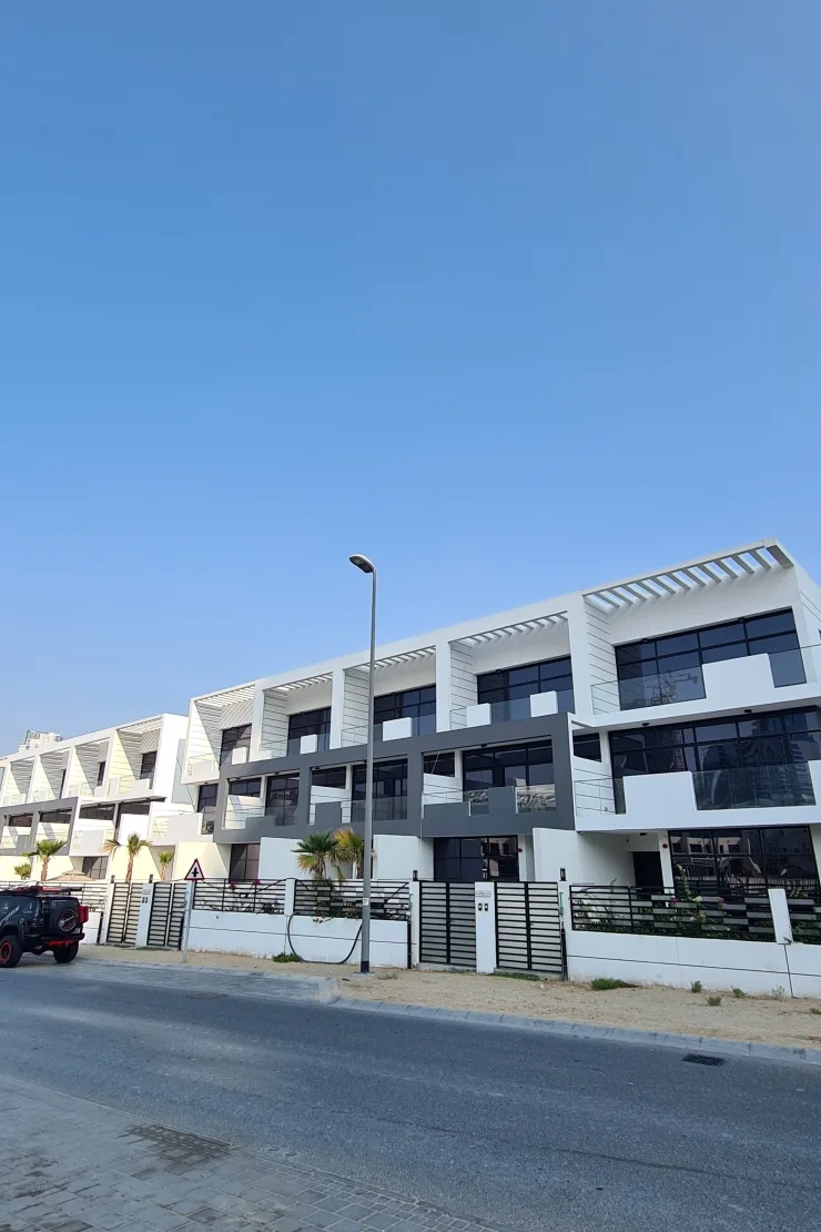 Street view of white townhouse row with pergolas