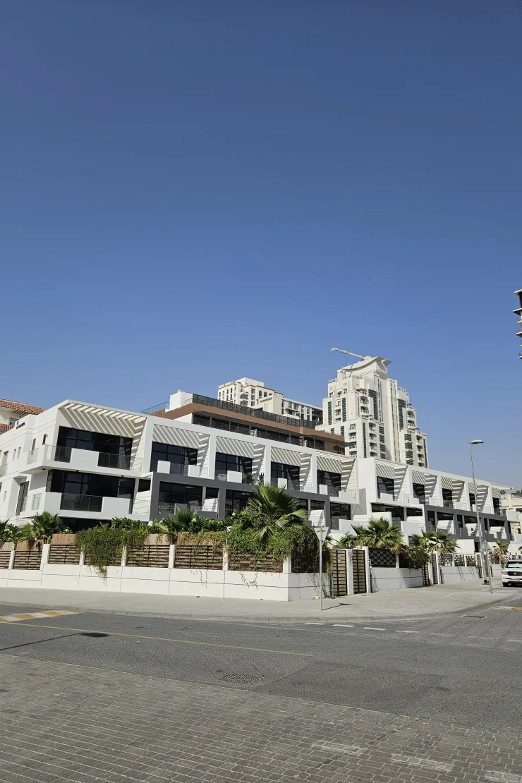 Townhouse row with louvered facades and landscaping