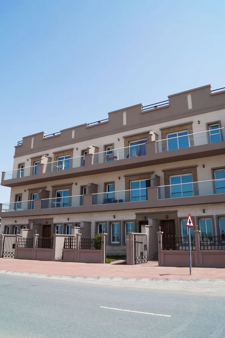 Three-storey townhouse-style block with balconies, street view