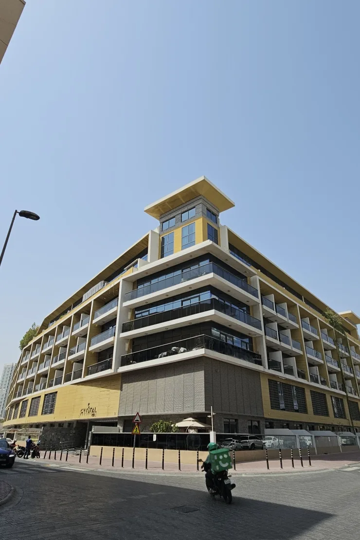 Corner view of completed gold-clad building with crown