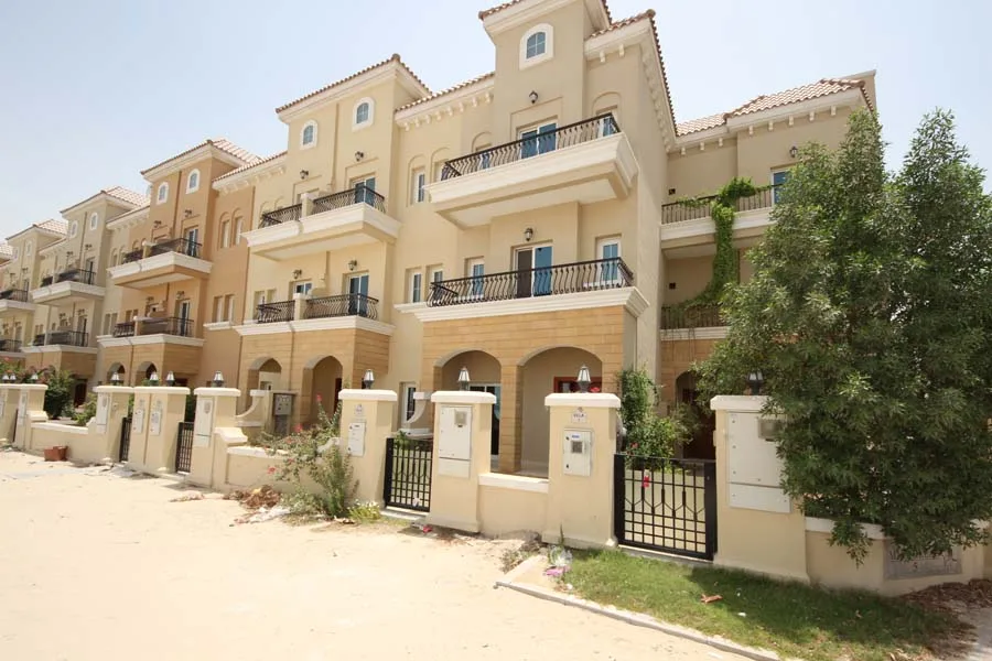 Row of Mediterranean-style townhouses with balconies and gates