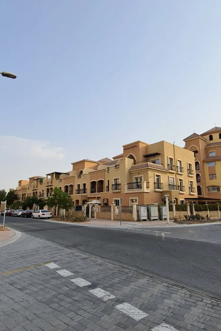 Street view of terracotta-toned low-rise townhouse blocks