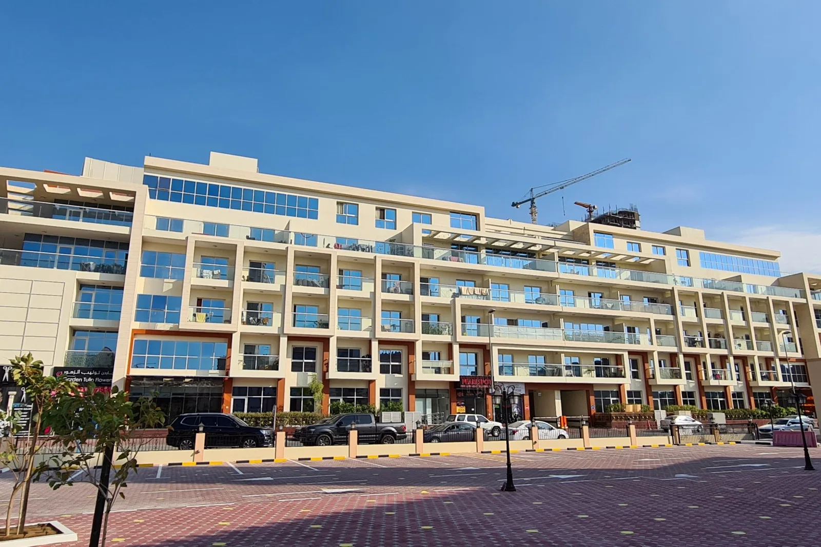 Completed mid-rise with ground-floor retail and balconies