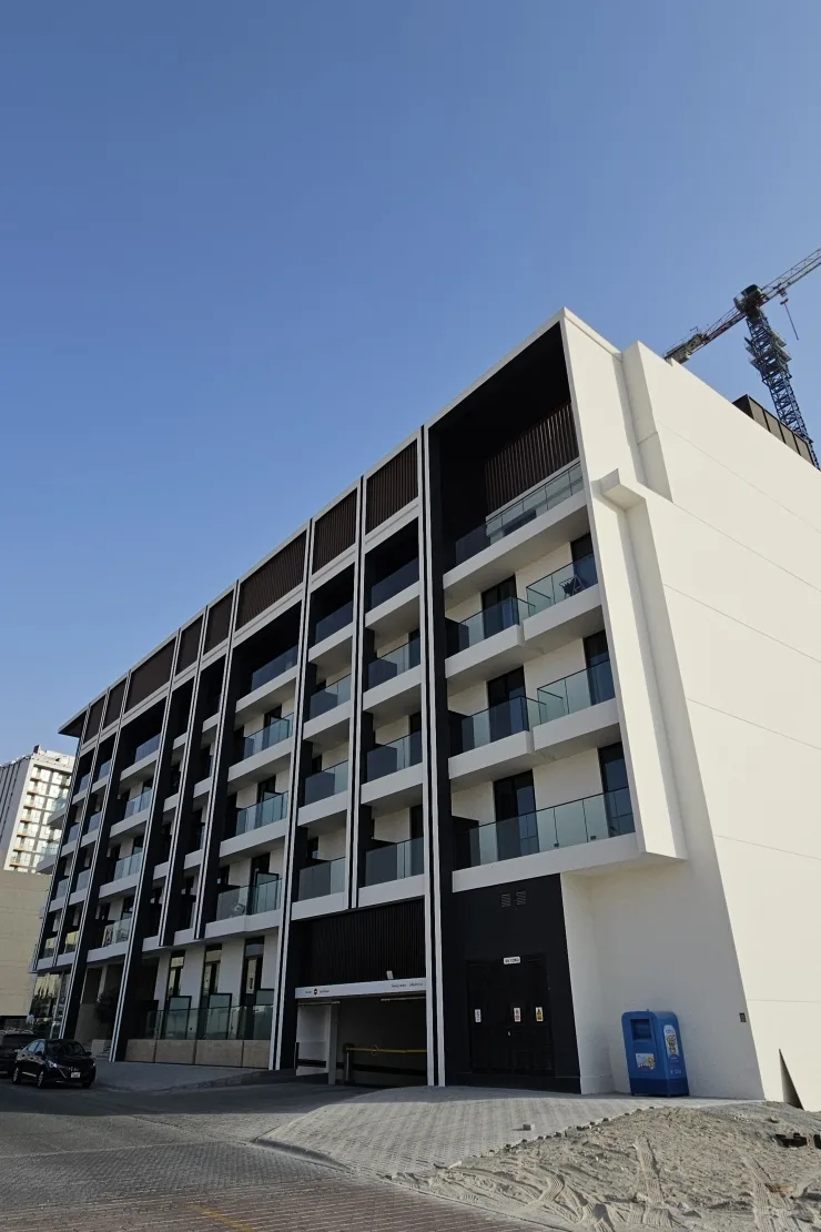 Side view of the completed building, dark framing and balconies