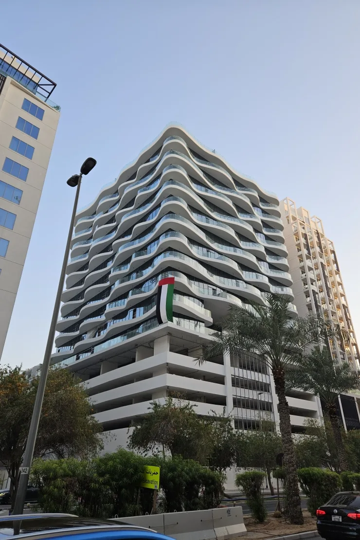 Wavy white balcony facade, completed tower seen from street