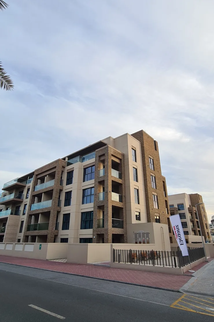 Completed corner of Eleganz with brick-clad balconies from street
