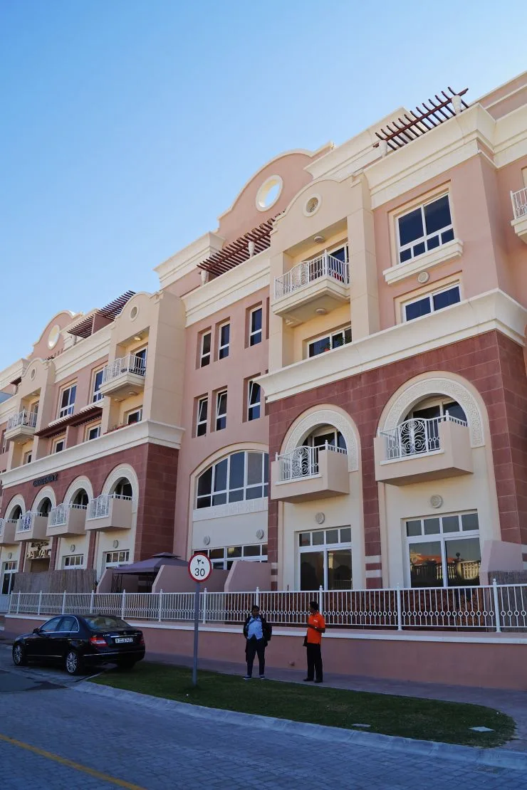 Pink Mediterranean-style facade with arched balconies, ground to roof