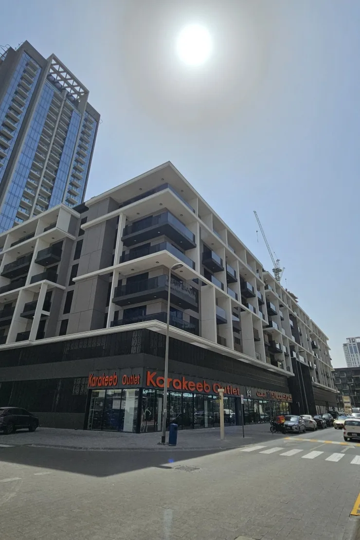 Corner view of the completed building with ground-floor retail