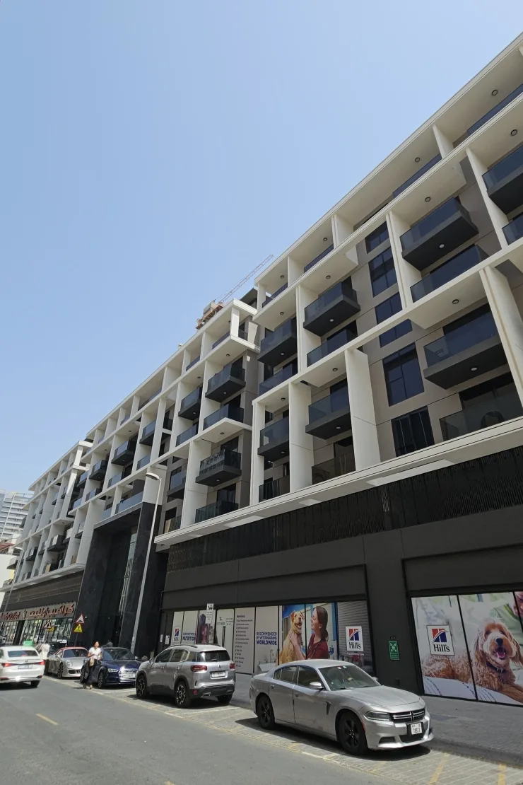 Street-side facade with stepped balconies and retail podium