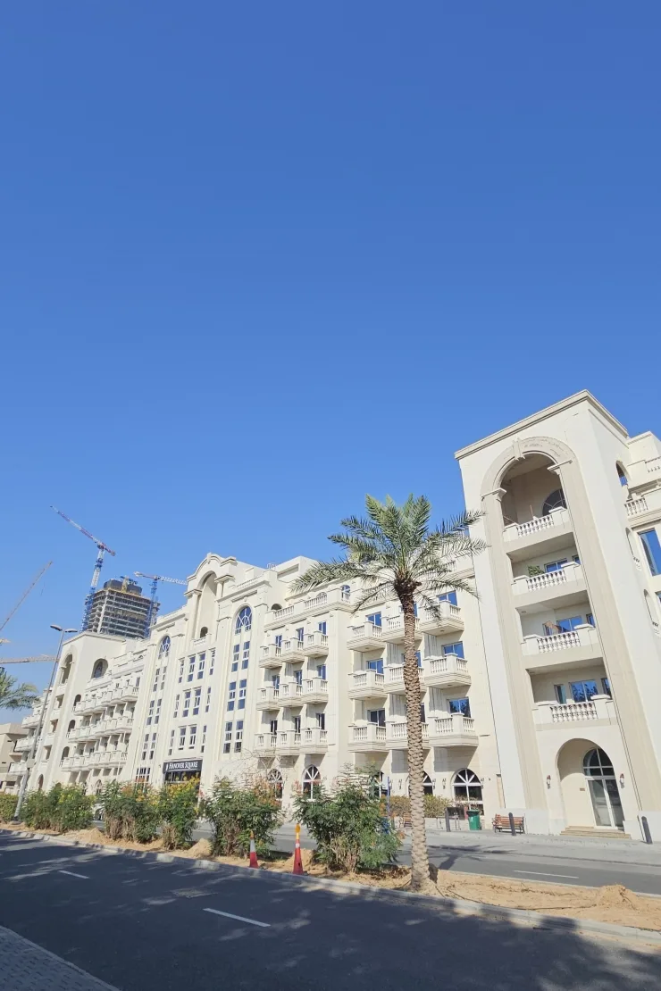 Cream arched facade with balconies along the street
