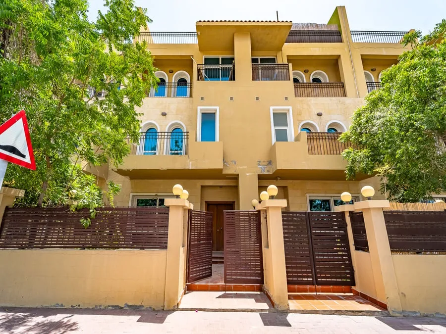 Townhouse facade with arched windows and gated entrance