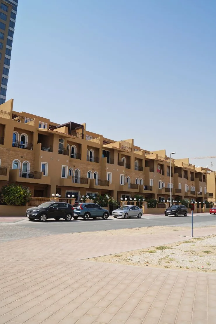 Street view of terraced sandstone facade with balconies
