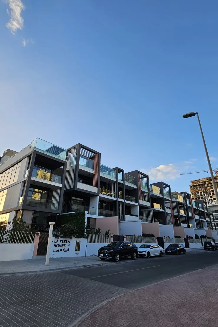 Completed townhouse row with La Perla Homes signage