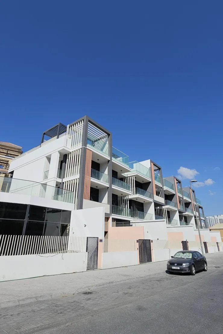 Stepped low-rise block with glass balconies and fins