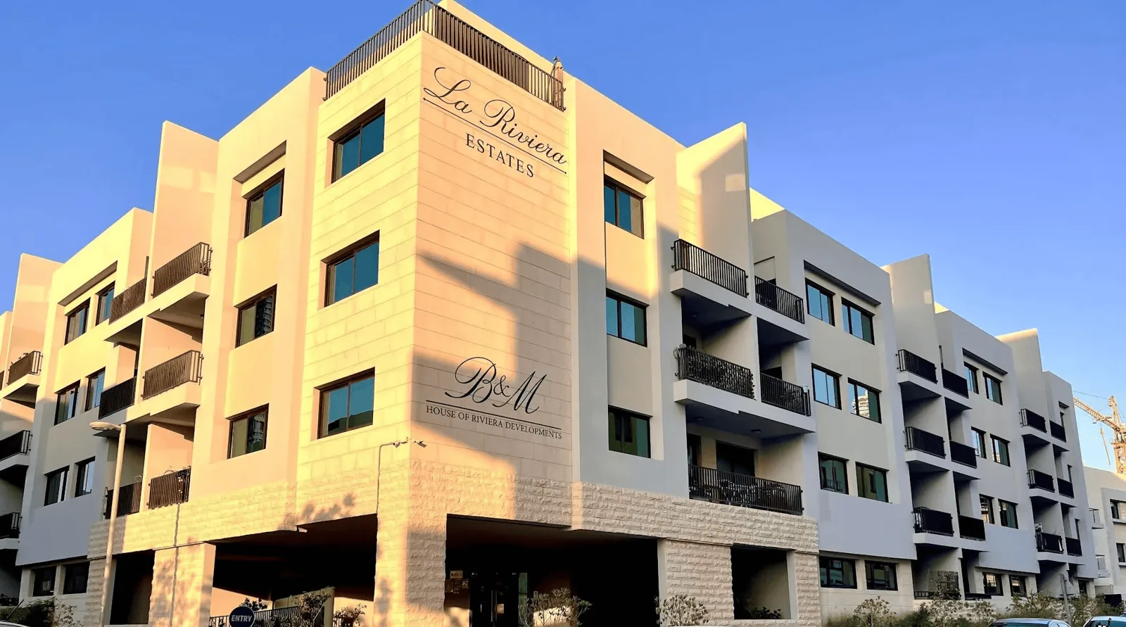 Corner facade with La Riviera Estates signage, full height