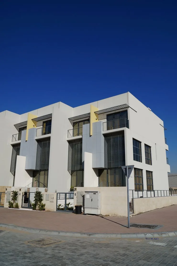 Corner townhouse block, white facade with yellow fins