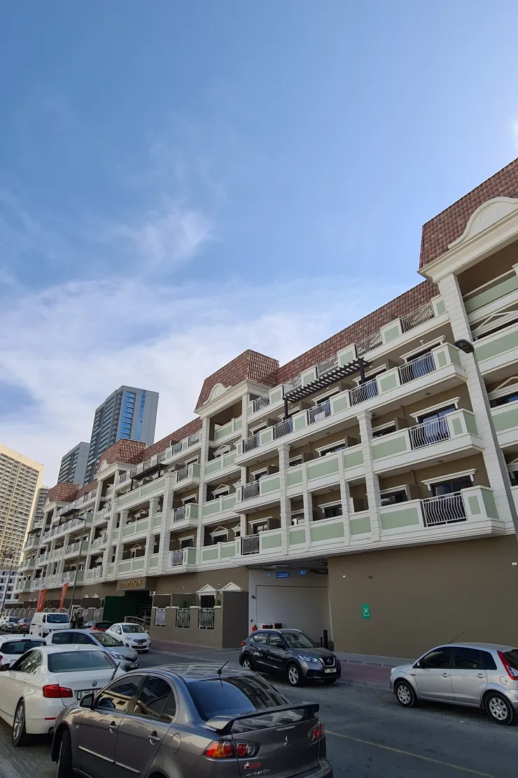Street-side facade with green balconies and tiled roof