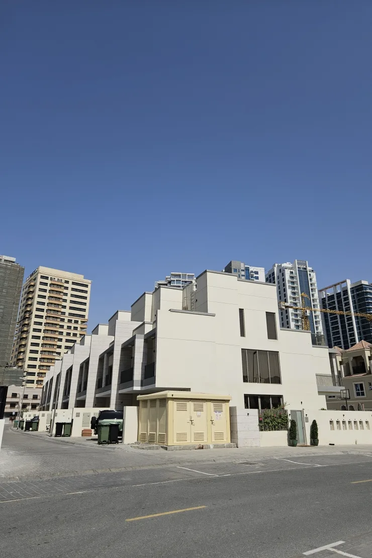 End of townhouse row, cream facade, street view