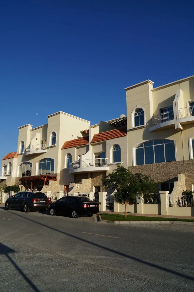 Cream townhouse-style row with terracotta roofs, street view