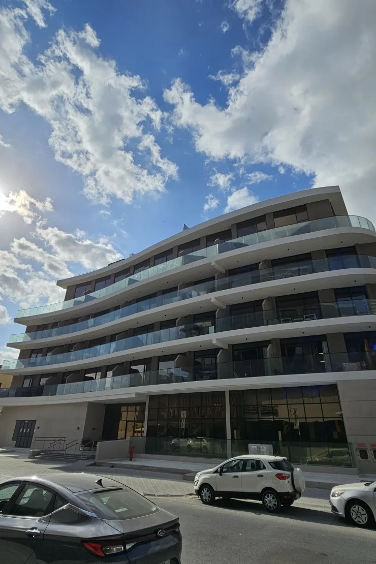Curved balconied facade with ground-floor glazing