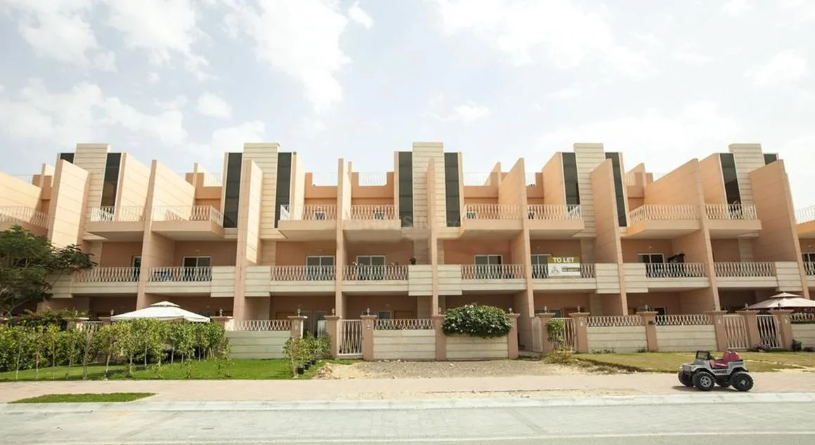 Front facade of peach townhouse row with gardens