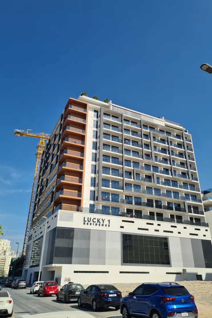 Completed tower from street, Lucky 1 Residence sign on podium