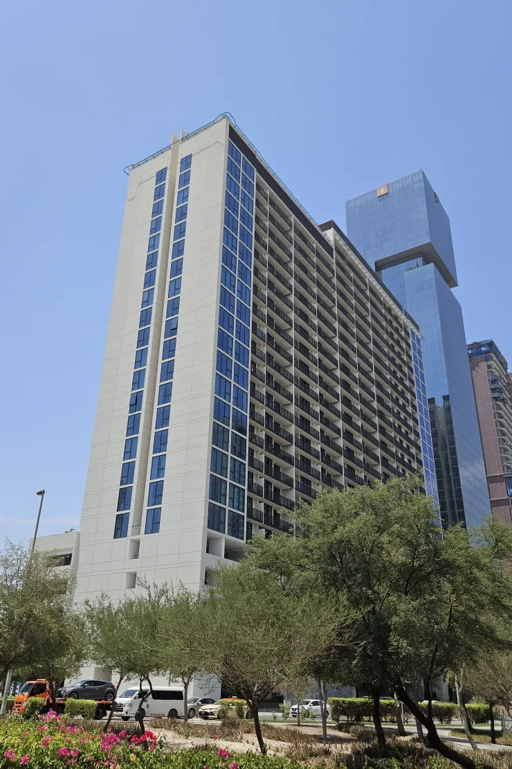 Street-level view of white tower with blue glazing strips