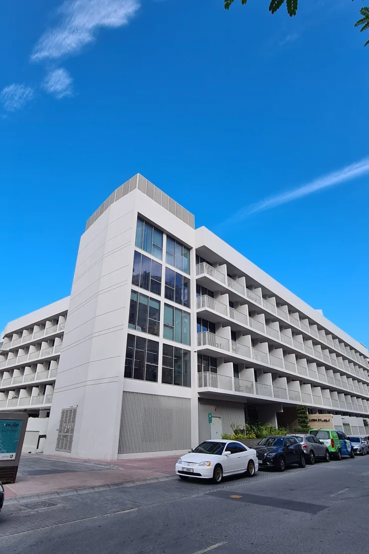 Completed white building seen from street, full height