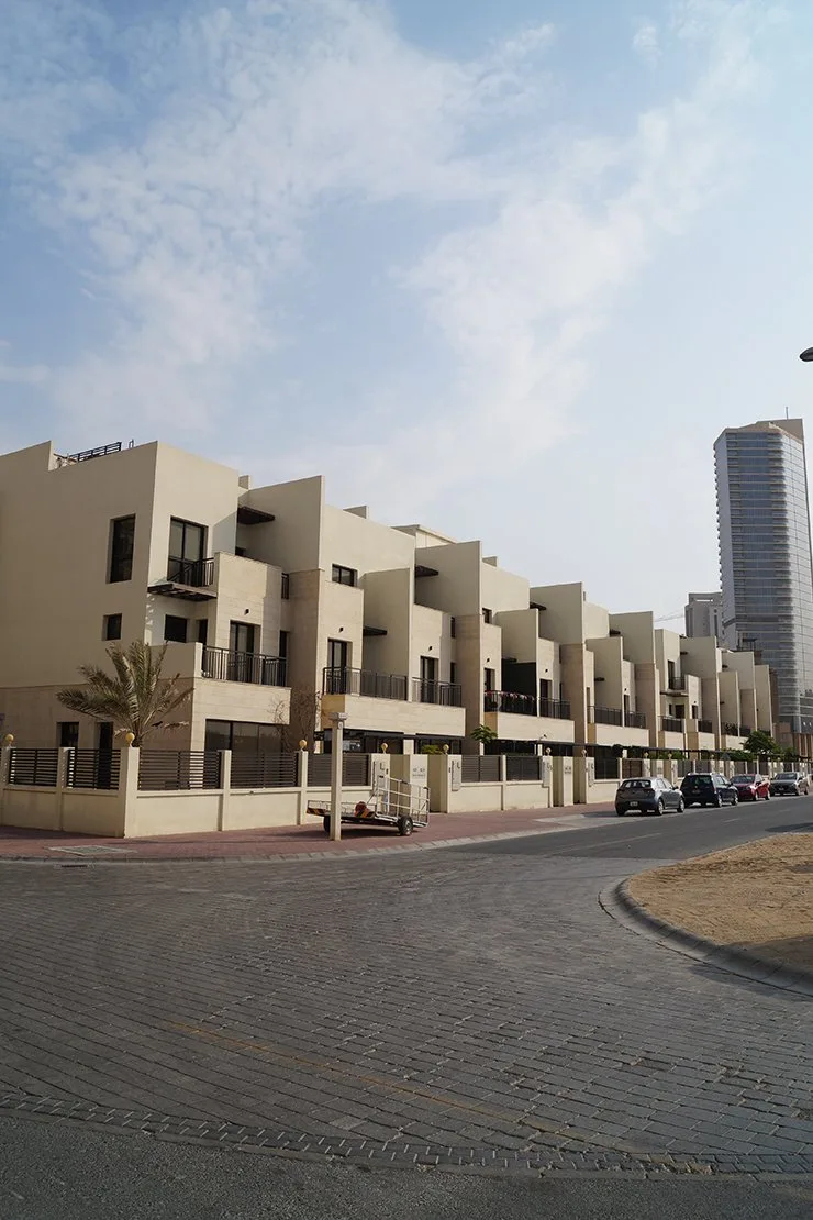 Stepped cream townhouse row seen from the street