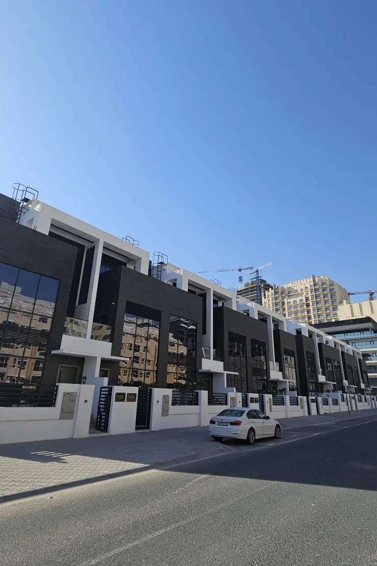 Completed townhouse row with dark cladding and white frames