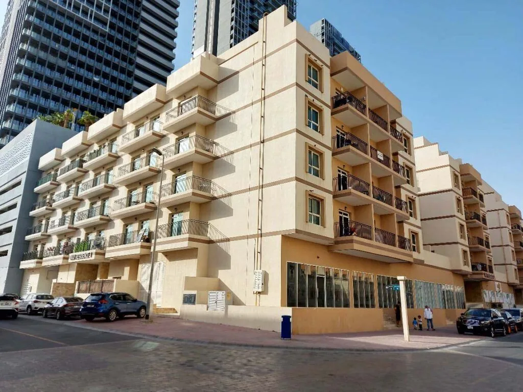 Corner view of completed beige building with balconies