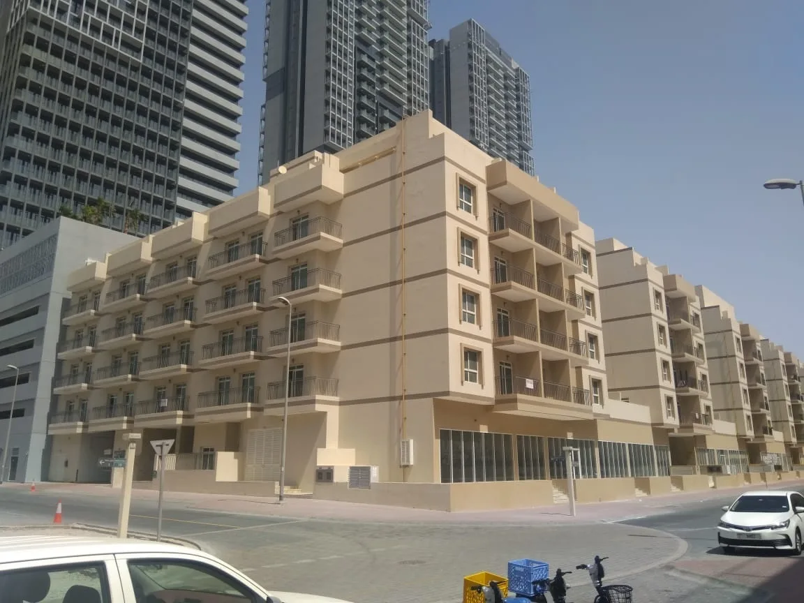 Beige low-rise May Residence block with balconies and ground-floor shops