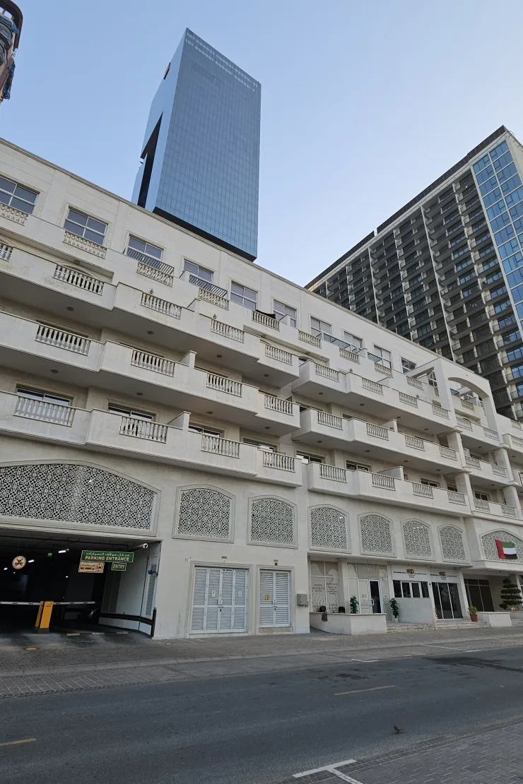Street view of balconies, lattice panels, parking entrance