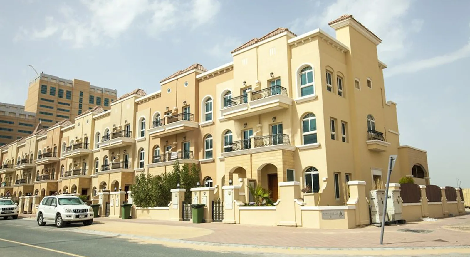 Yellow Mediterranean low-rise with arched windows and balconies