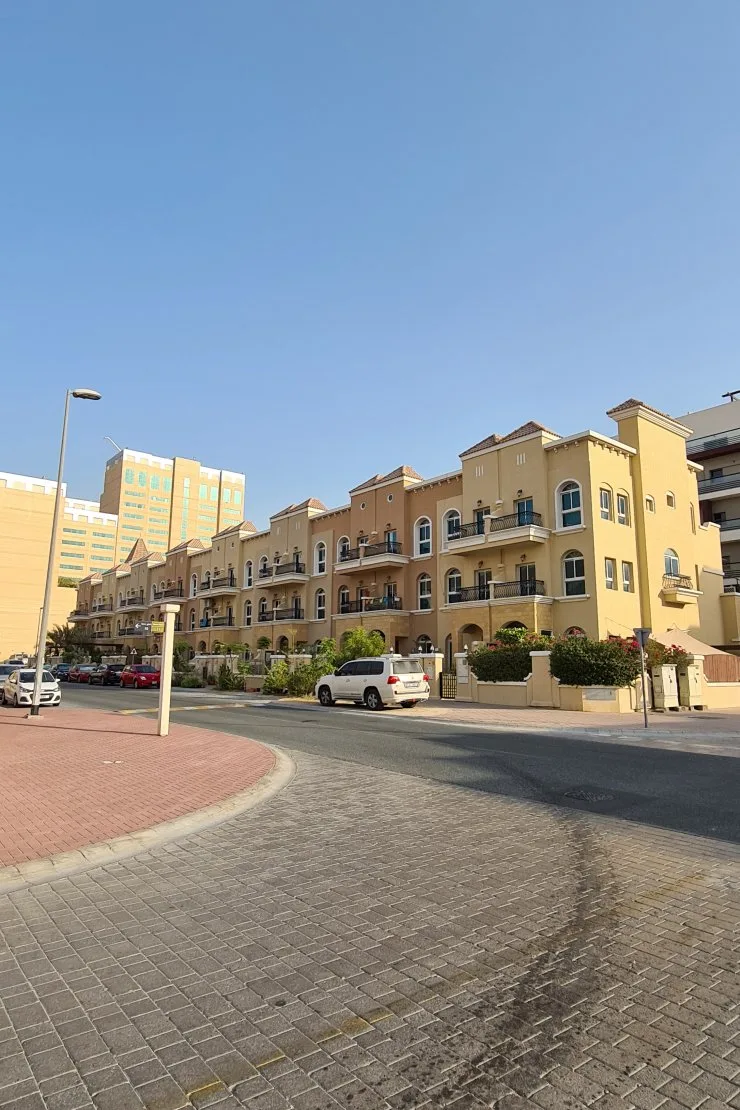Row of yellow Mediterranean-style blocks seen from the street