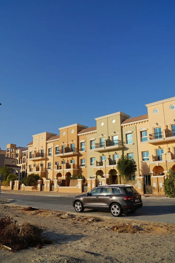 Ochre Mediterranean townhouse block with balconies and arches