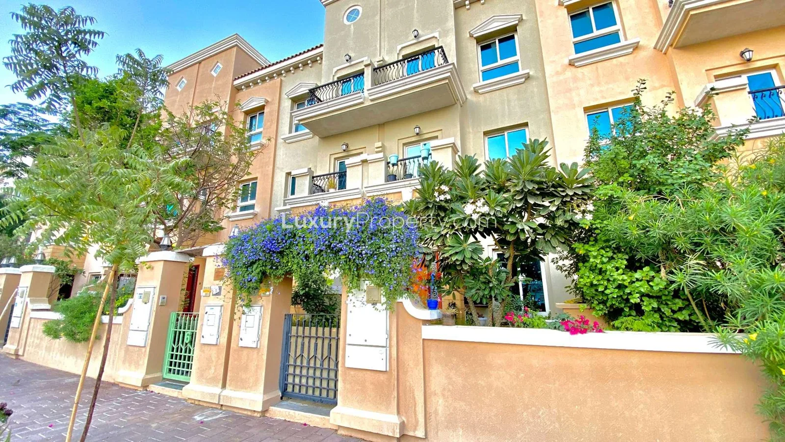 Townhouse facade with balcony, gated entrance and planting