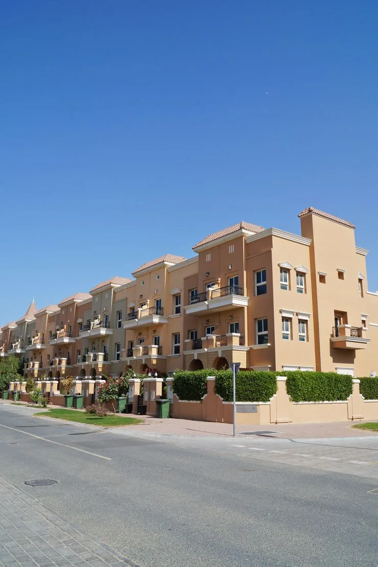 Long terracotta-toned block with balconies, seen from street
