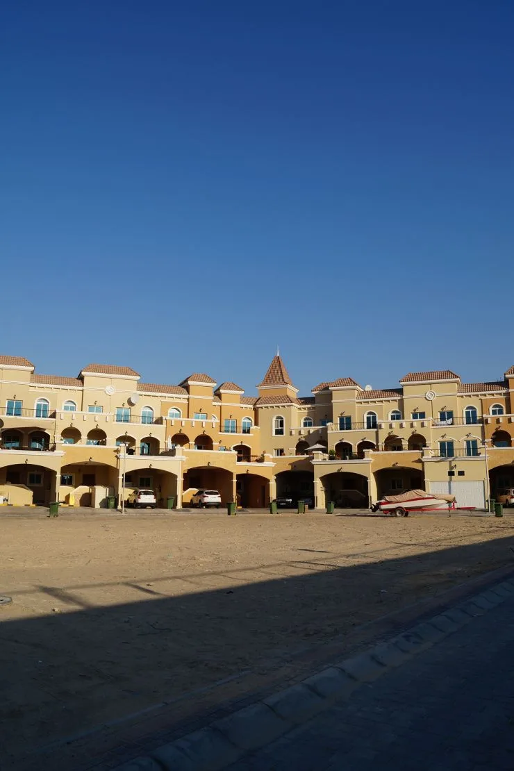 Cream Mediterranean facade with terracotta roofs and arcades