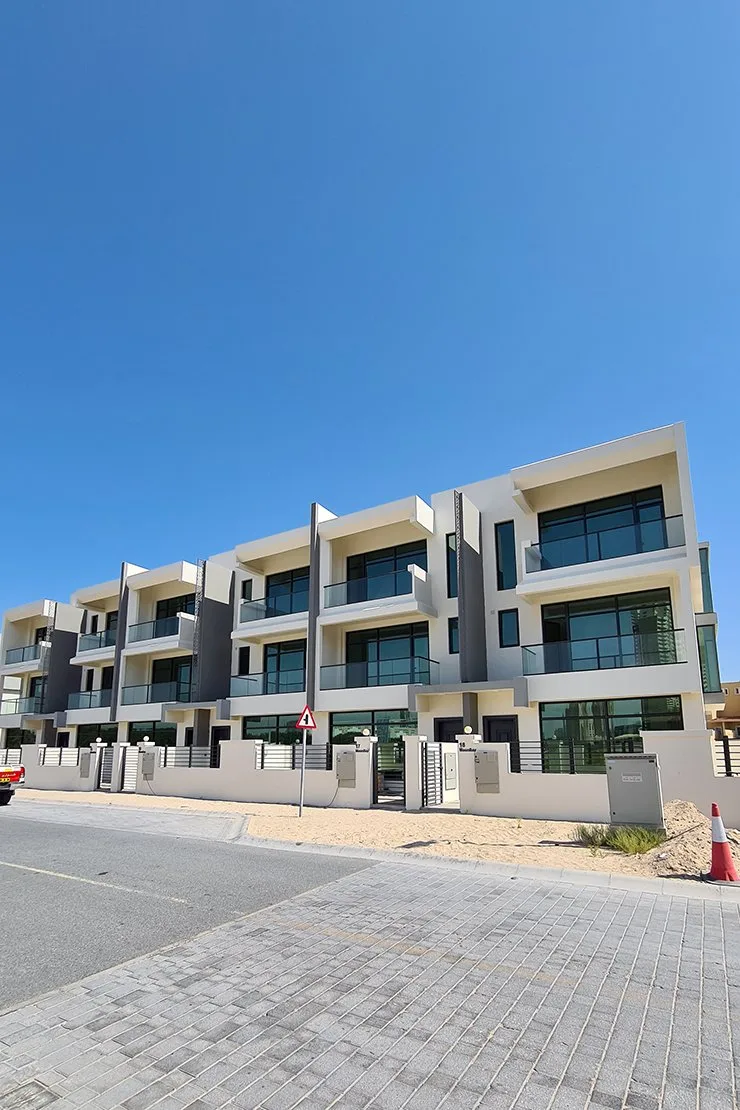 Row of three-storey white townhouses with balconies